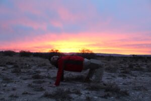 person doing a crab walk at sunset or sunrise