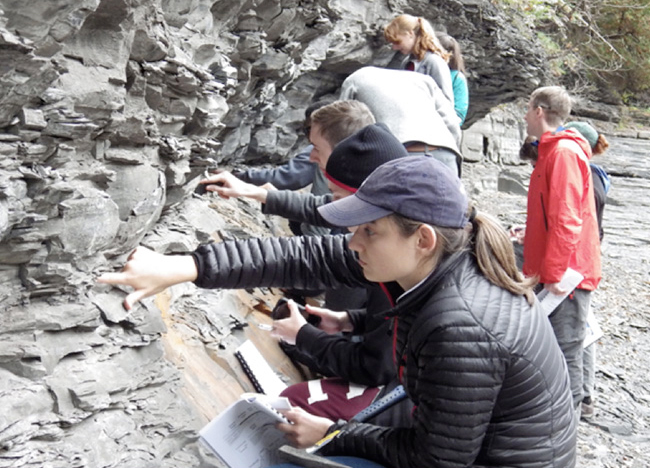 Students studying a rocky outcropping.